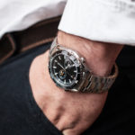 close-up men's wrist watch in white shirt hand in black trousers pocket article about men's style or luxury watches lifestyle of a winner.